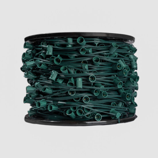 A front-on view of a black plastic spool completely filled with coiled, dark green light stringer and empty bulb sockets.
