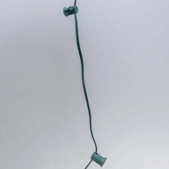 Close-up of bulk C7 light string wire with green sockets spaced 12 inches apart on a dark green wire. C7 Spool 12" Spacing Green 1000' Spool