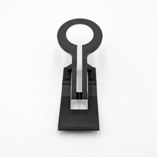 A small, black plastic clip or hanging hardware, shaped like a keyhole with a flat, stepped base, on a white background.