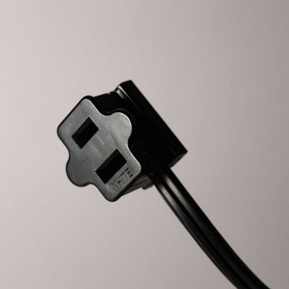 Close-up view of the female (receptacle) end of a black, two-prong extension or connector cord.