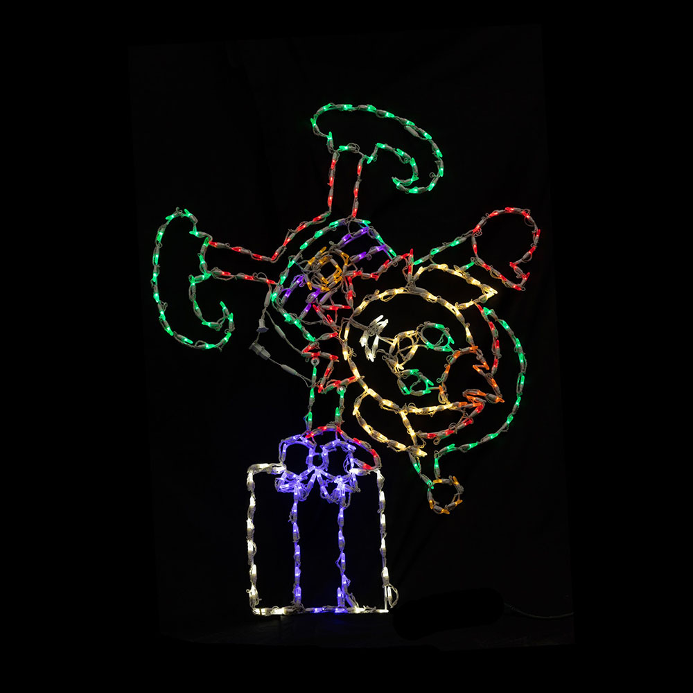 A multi-colored light motif of an elf carrying stacked gifts. The wire frame uses red and green lights (body/gifts) with warm white (face) and purple accents.