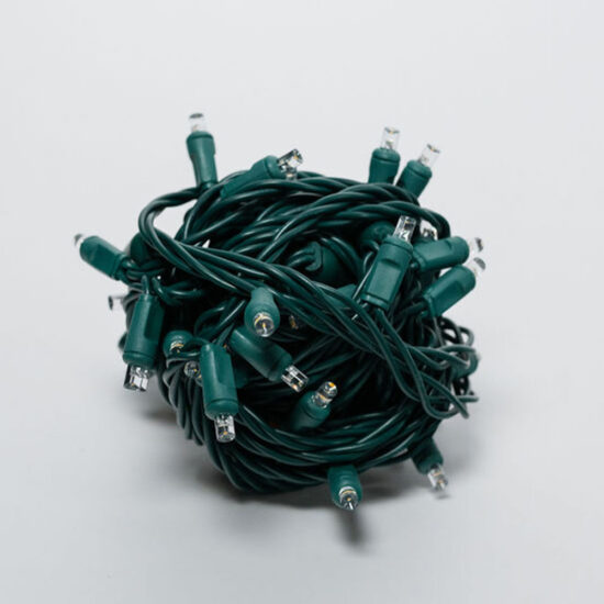 A tight, tangled ball of green wire LED string lights, featuring clear, mini-style bulbs.