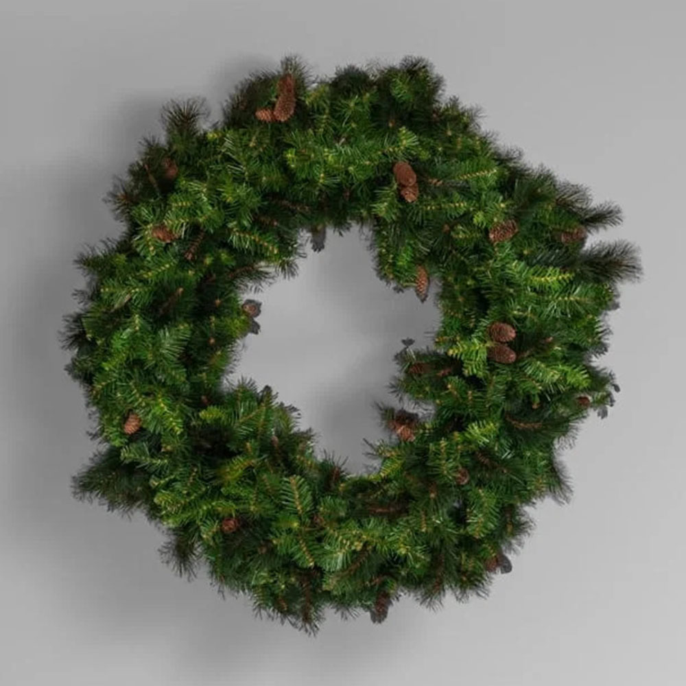 A thick, unlit artificial pine wreath decorated solely with natural pine cones, displayed against a solid gray background.