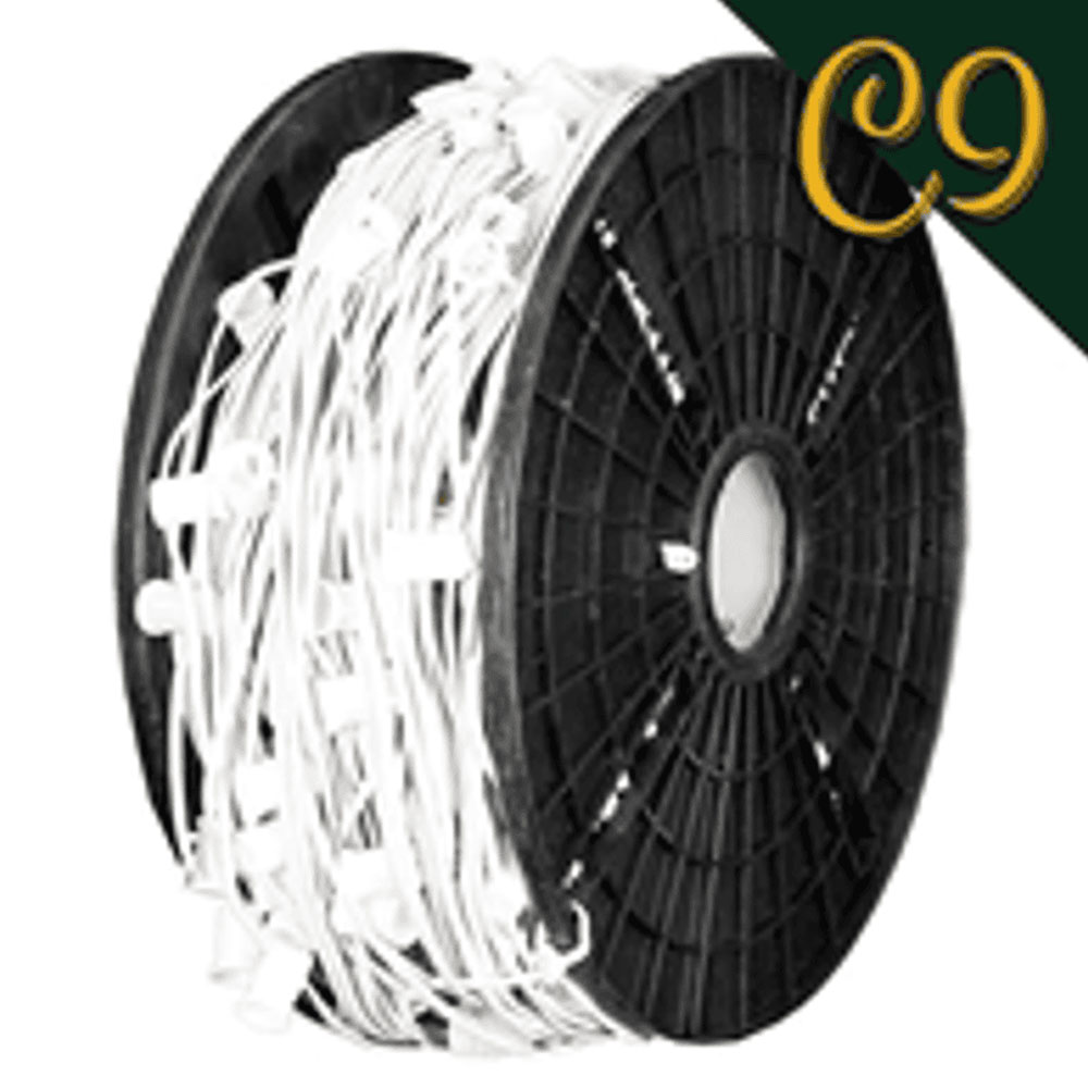 Industrial view of a reel tightly wound with white electrical wire and numerous small, white lamp holders for decorative lighting.