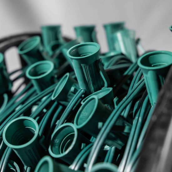 Bulk spool of C9 light stringer wire with green sockets and wire, shown tightly packed in a container. C9 Spool 18" Spacing Green 1000'